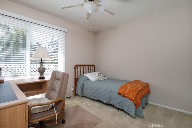 carpeted bedroom with ceiling fan and baseboards