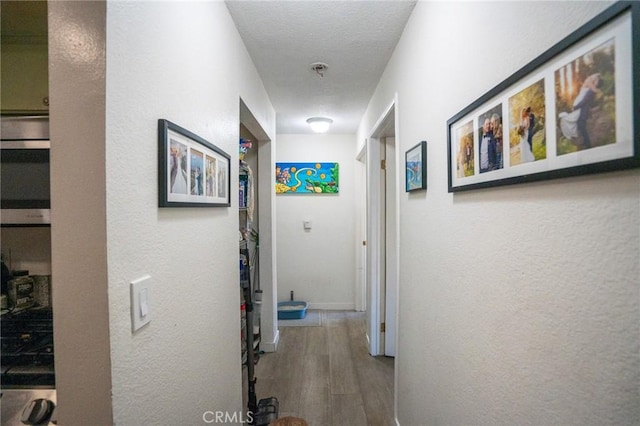 327 Chestnut Ave Unit 201, Long Beach, CA 90802 - corridor with wood finished floors, a textured wall, and baseboards