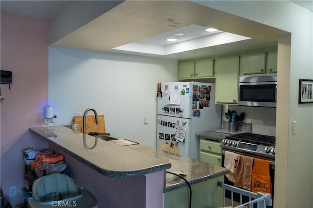 327 Chestnut Ave Unit 201, Long Beach, CA 90802 - kitchen featuring appliances with stainless steel finishes, green cabinetry, a peninsula, a breakfast bar area, and a raised ceiling