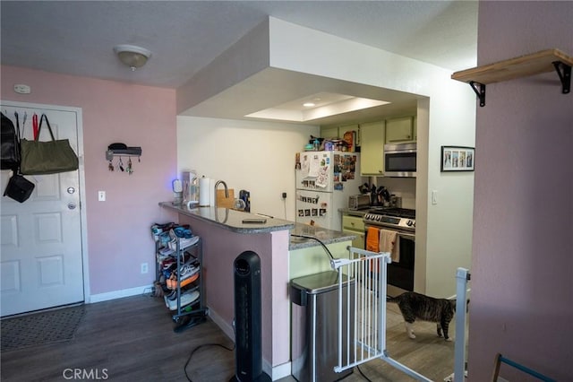 327 Chestnut Ave Unit 201, Long Beach, CA 90802 - kitchen with stainless steel appliances, wood finished floors, a peninsula, baseboards, and a kitchen bar