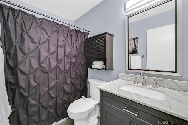 bathroom featuring toilet, curtained shower, and vanity