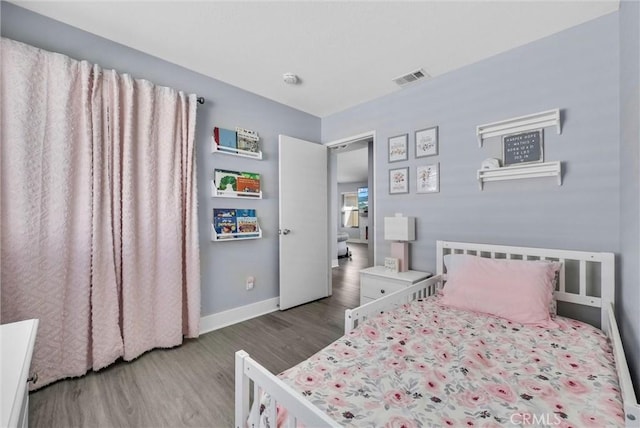 bedroom featuring baseboards, visible vents, and wood finished floors