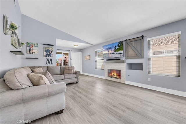 976 Miraflores Dr, Corona, CA 92882 - living room with lofted ceiling, light wood-type flooring, and a glass covered fireplace