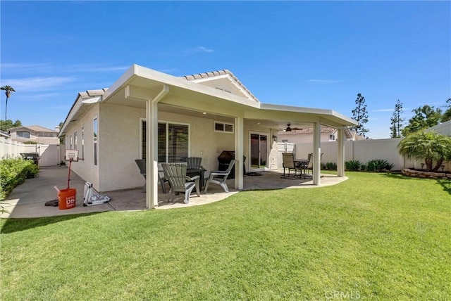 back of property with a yard, stucco siding, a fenced backyard, and a patio