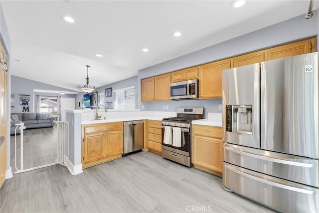 kitchen featuring lofted ceiling, recessed lighting, light wood-style floors, light countertops, and appliances with stainless steel finishes