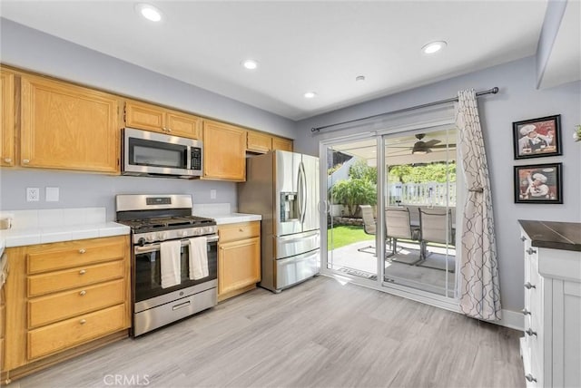 976 Miraflores Dr, Corona, CA 92882 - kitchen with stainless steel appliances, light wood-style flooring, recessed lighting, and tile countertops