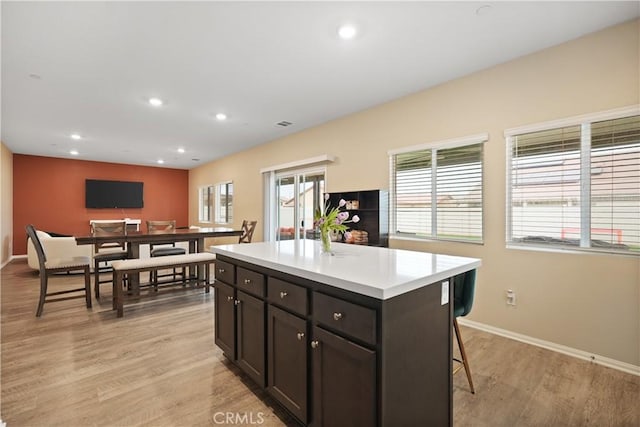 26643 Baneberry Ct, Menifee, CA 92585 - kitchen with baseboards, light wood finished floors, a kitchen island, light countertops, and recessed lighting