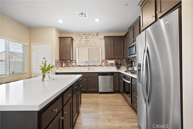 26643 Baneberry Ct, Menifee, CA 92585 - kitchen with stainless steel appliances, a sink, dark brown cabinets, light countertops, and recessed lighting