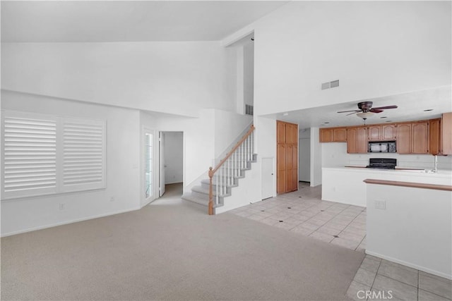 8 Tamarac Pl, Aliso Viejo, CA 92656 - unfurnished living room with light tile patterned floors, a ceiling fan, visible vents, a towering ceiling, and stairs