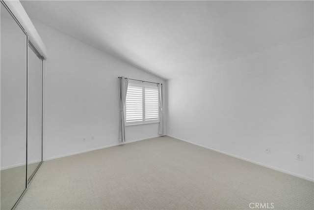 8 Tamarac Pl, Aliso Viejo, CA 92656 - unfurnished bedroom featuring a closet, vaulted ceiling, baseboards, and light carpet