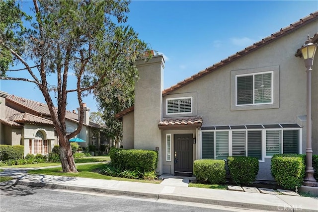 8 Tamarac Pl, Aliso Viejo, CA 92656 - view of front facade featuring stucco siding, a tiled roof, and a chimney