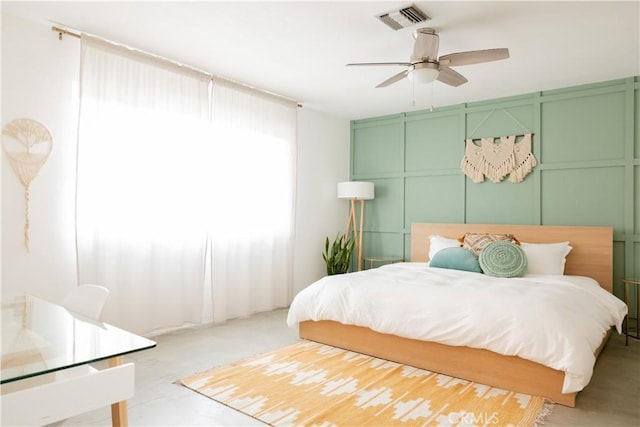bedroom with a decorative wall and a ceiling fan