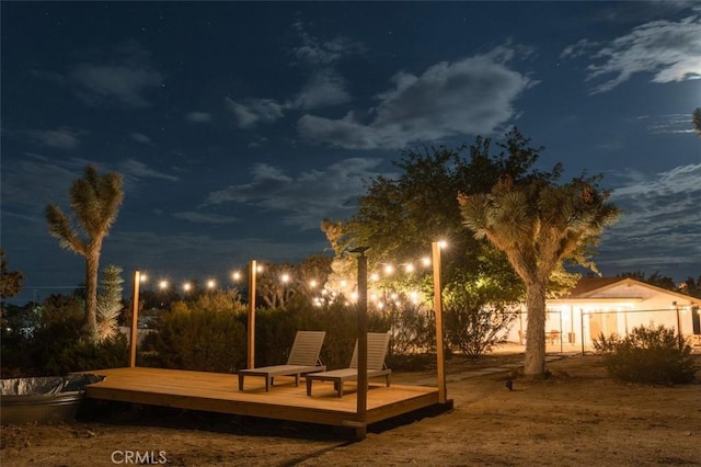 yard at night with a deck and fence