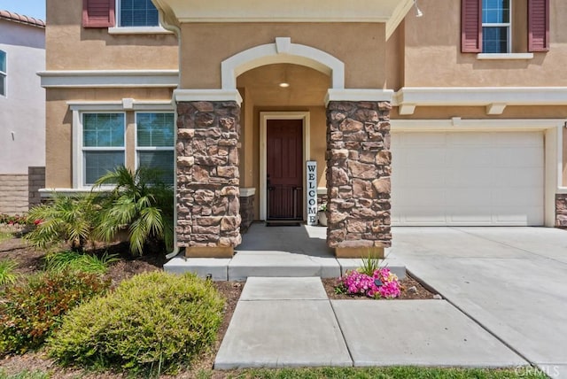19321 Carranza Ln, Saugus, CA 91350 - property entrance with stone siding, stucco siding, driveway, and an attached garage