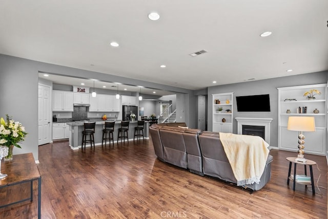 19321 Carranza Ln, Saugus, CA 91350 - living room with wood finished floors, built in shelves, stairway, recessed lighting, and a fireplace