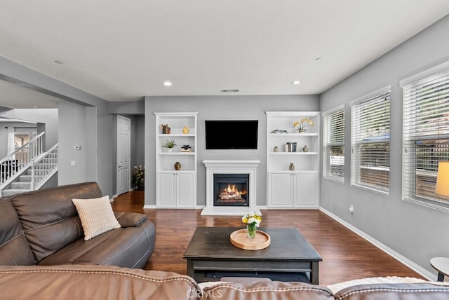19321 Carranza Ln, Saugus, CA 91350 - living area featuring stairway, a glass covered fireplace, visible vents, and wood finished floors