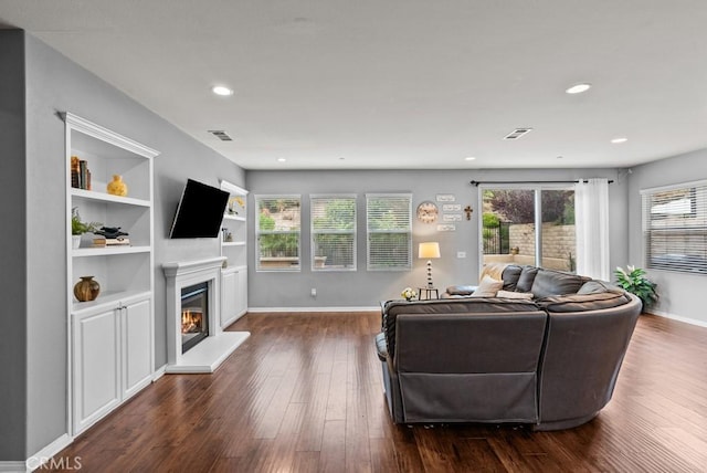 19321 Carranza Ln, Saugus, CA 91350 - living room with dark wood-style flooring, a wealth of natural light, a glass covered fireplace, and visible vents