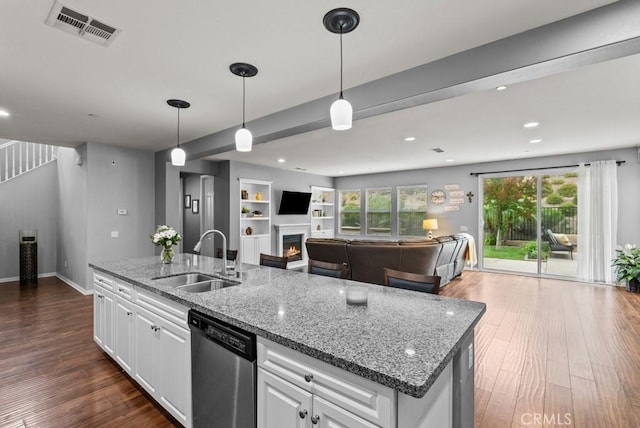 19321 Carranza Ln, Saugus, CA 91350 - kitchen with a sink, dark wood finished floors, stainless steel dishwasher, visible vents, and a warm lit fireplace