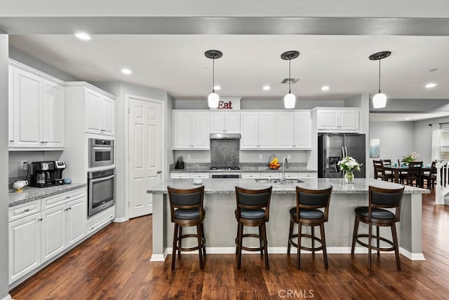19321 Carranza Ln, Saugus, CA 91350 - kitchen with a sink, a large island with sink, white cabinetry, stainless steel fridge, and dark wood-style floors