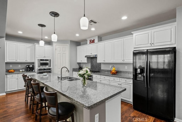 19321 Carranza Ln, Saugus, CA 91350 - kitchen with black fridge with ice dispenser, a sink, white cabinets, recessed lighting, and an island with sink