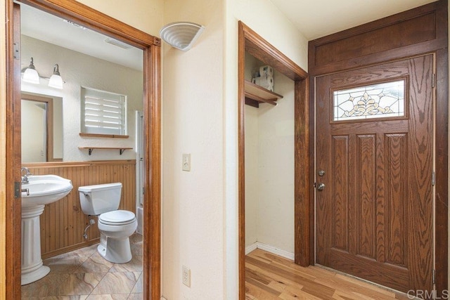 bathroom featuring wainscoting, toilet, and wood walls