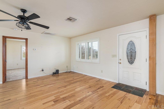 foyer featuring a ceiling fan, light wood-style floors, visible vents, and baseboards