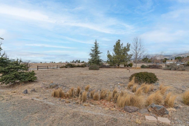 view of yard featuring a rural view and fence