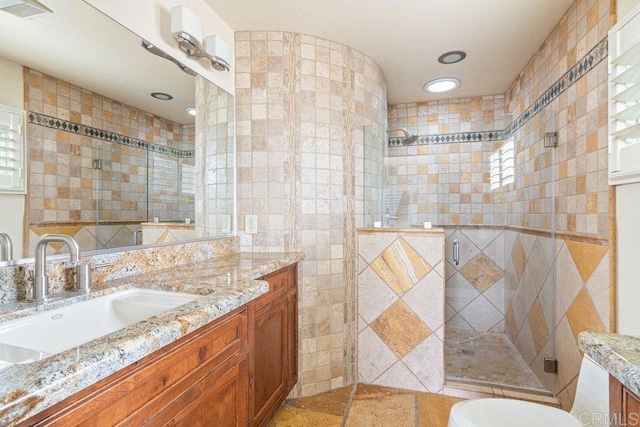 full bathroom featuring a stall shower, tile walls, visible vents, vanity, and recessed lighting