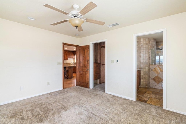 unfurnished bedroom featuring a sink, ensuite bath, visible vents, carpet floors, and baseboards