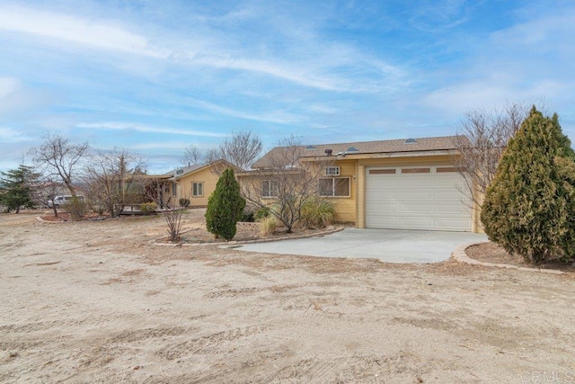 ranch-style home with concrete driveway and a garage