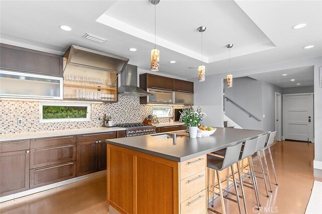 291 Argonne Ave, Long Beach, CA 90803 - kitchen with wall chimney exhaust hood, tasteful backsplash, a center island with sink, recessed lighting, and a tray ceiling