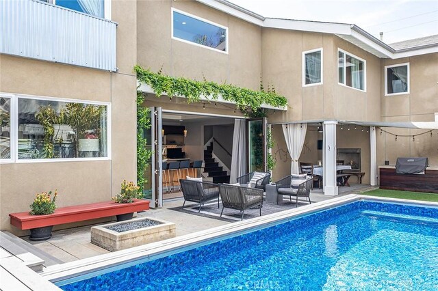 291 Argonne Ave, Long Beach, CA 90803 - back of house featuring outdoor lounge area, stucco siding, a patio area, and an outdoor pool