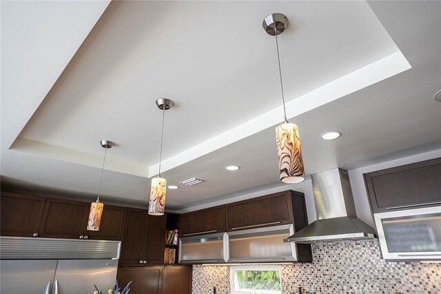 291 Argonne Ave, Long Beach, CA 90803 - detailed view of wall chimney range hood, fridge, dark brown cabinetry, decorative light fixtures, and backsplash