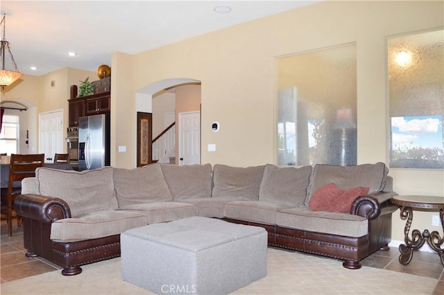 13622 Canyon Crest Rd, Yucaipa, CA 92399 - living room featuring arched walkways, stairs, and light tile patterned floors