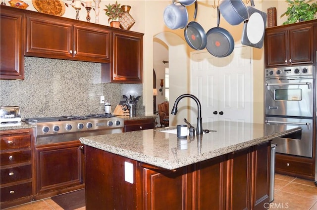 13622 Canyon Crest Rd, Yucaipa, CA 92399 - kitchen with stainless steel appliances, a sink, dark brown cabinets, and light tile patterned flooring