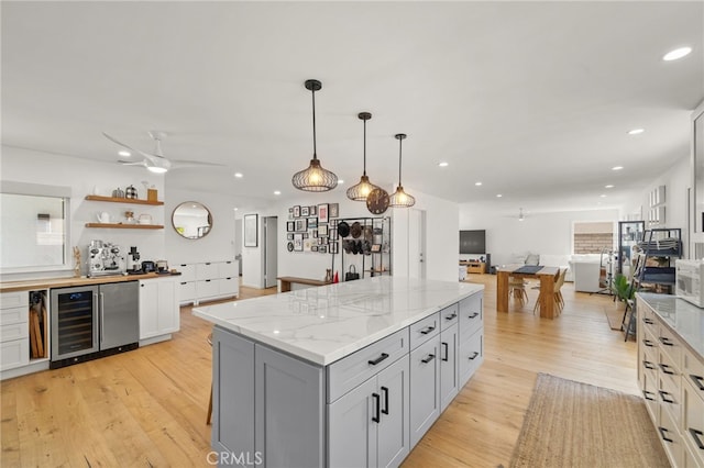 19542 Constellation Ln, Huntington Beach, CA 92646 - kitchen featuring open shelves, light wood-type flooring, open floor plan, a center island, and beverage cooler