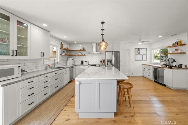 19542 Constellation Ln, Huntington Beach, CA 92646 - kitchen with stainless steel appliances, open shelves, a sink, and a breakfast bar area