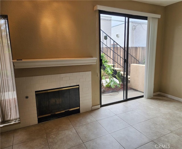 unfurnished living room with baseboards, tile patterned floors, and a fireplace