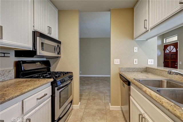 4560 Cleveland Ave Unit 101, San Diego, CA 92116 - kitchen with appliances with stainless steel finishes, a sink, light tile patterned floors, baseboards, and white cabinets