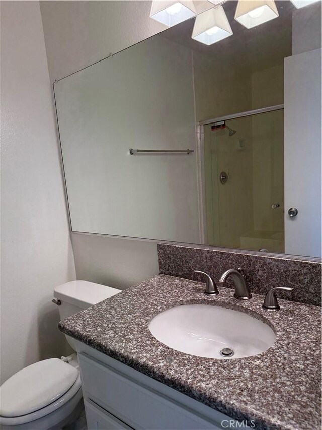 full bathroom with a stall shower, vanity, toilet, and a skylight