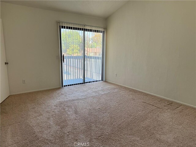 spare room featuring carpet flooring and baseboards