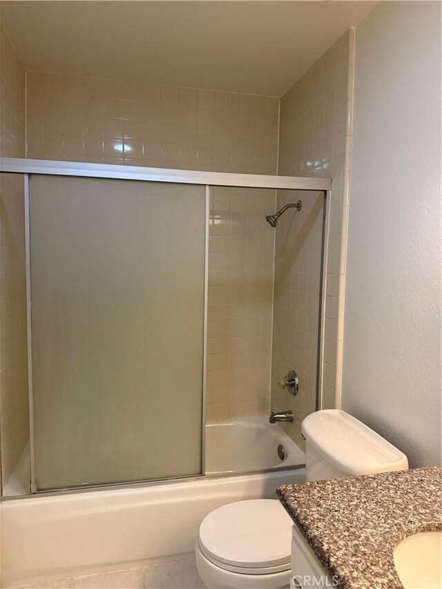 full bath with toilet, shower / bath combination with glass door, and vanity