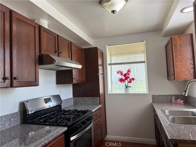 20821 E Calora St Unit E1, Covina, CA 91724 - kitchen with stainless steel gas range, a sink, under cabinet range hood, and baseboards