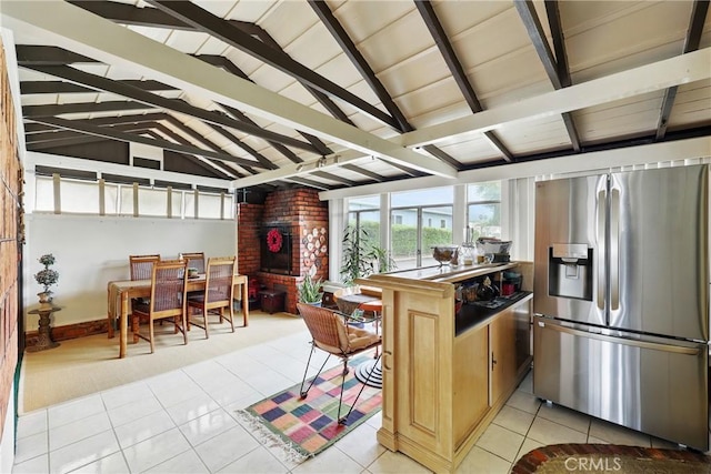 kitchen featuring stainless steel refrigerator with ice dispenser, healthy amount of natural light, light tile patterned floors, and light colored carpet