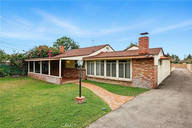 rear view of house with a chimney and brick siding