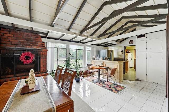 dining space featuring a brick fireplace and light tile patterned flooring