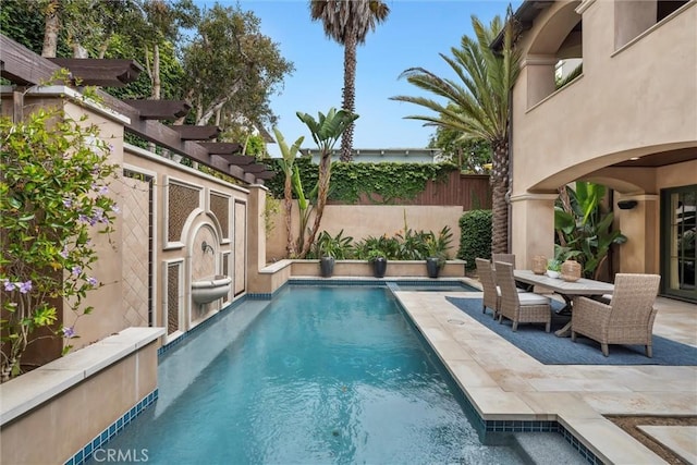 view of swimming pool with a fenced backyard, a patio area, and outdoor dining area