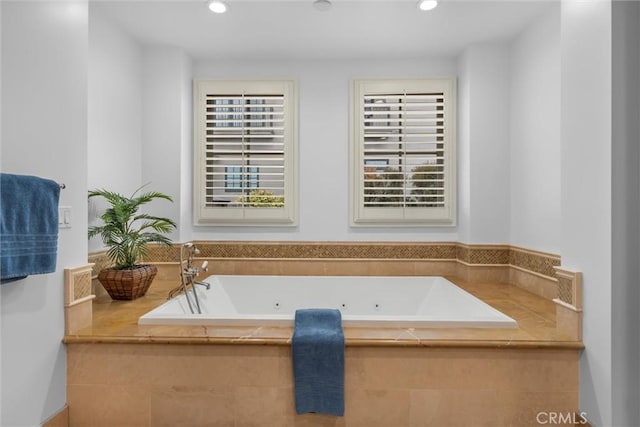 full bath featuring a tub with jets, recessed lighting, and healthy amount of natural light