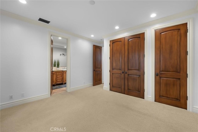 unfurnished bedroom with light carpet, recessed lighting, a closet, baseboards, and crown molding