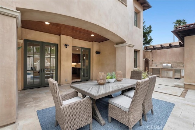 view of patio featuring french doors, exterior kitchen, and outdoor dining area